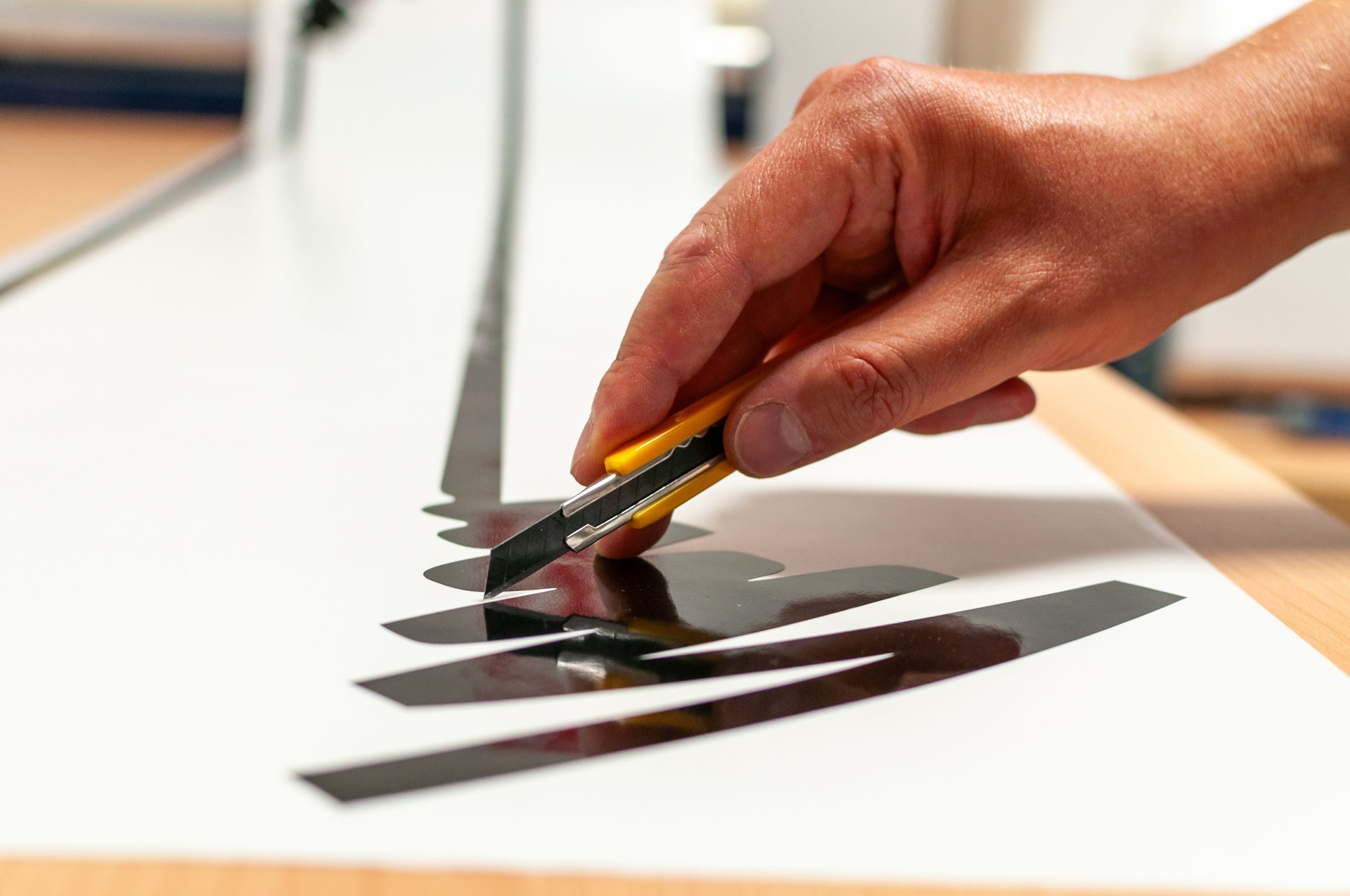 Close-up of the hand of a person making advertising stickers